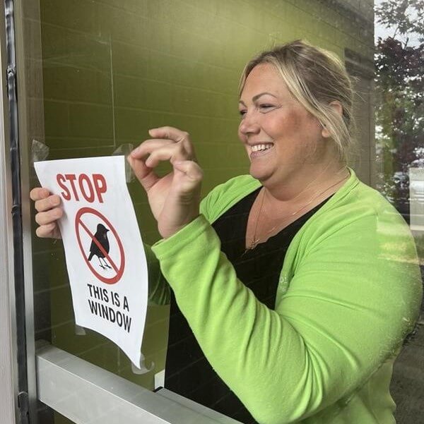 Choice One Engineering in‑house recruiter hangs a bird‑safety window sign to prevent birds from flying into office windows.